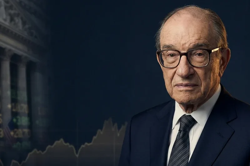 Portrait of Alan Greenspan, former Federal Reserve chairman, against a dark backdrop with a faded classical government building and a stock ticker