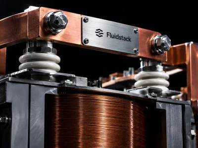 Close up of a copper transformer winding and switchgear busbar with a brushed steel nameplate reading Fluidstack