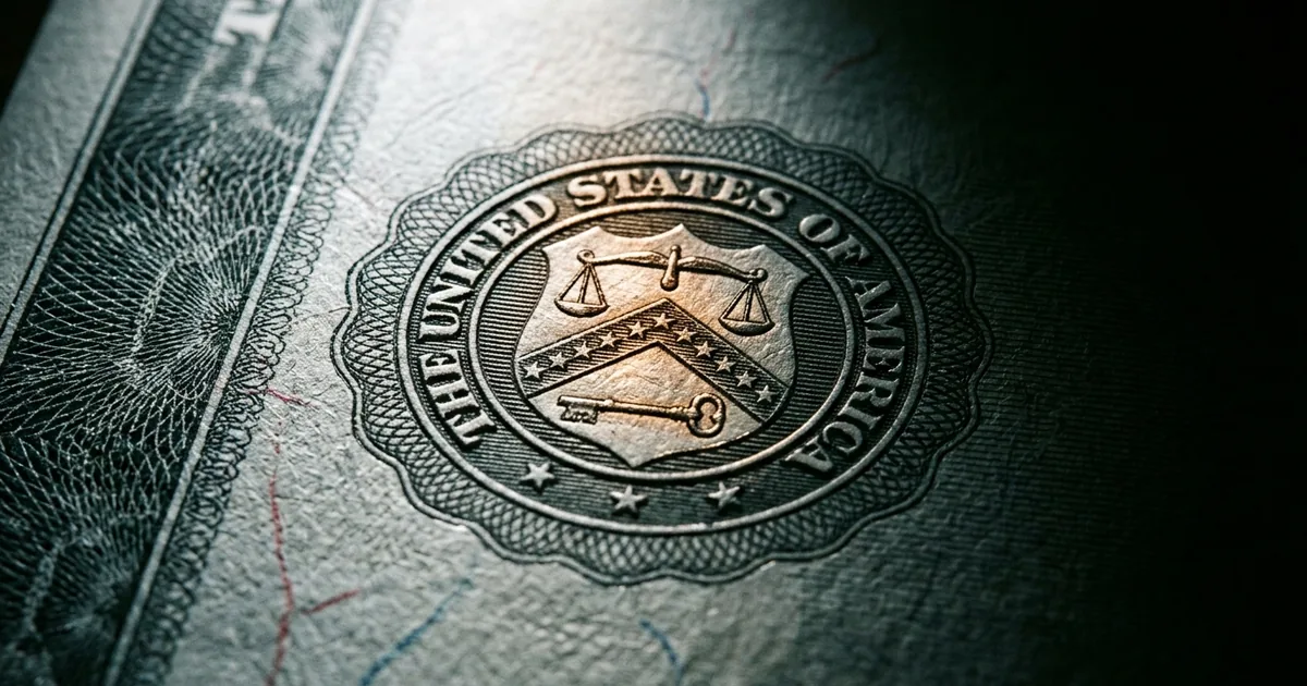 Extreme macro of an engraved United States Treasury bond certificate showing the Department of the Treasury seal in raking light